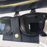 Clear crossbody bag with black trim, gold hardware, and a detachable sunglasses holder—fun, functional, and stadium-approved.
