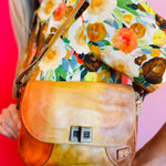 Elect leather shoulder bag with twist clasp, adjustable strap, and multiple interior and exterior pockets.