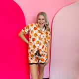 a pajama set with a checkered pumpkin print top and ruffle shorts.