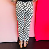 Back view of black and white cropped checkered jeans with knee distressing.