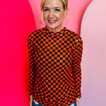 Orange and black checkered long sleeve mesh top for bold, breathable layering.