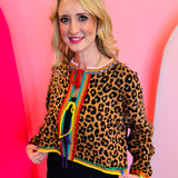 Leopard print rhinestone sweater with rainbow trim and adjustable front ties.