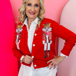 Red cardigan with sequined nutcracker designs and classic button-front silhouette.