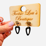 Hammered gold stud earrings with glossy black abstract drop shapes.