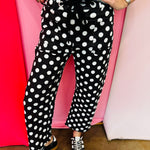 Black and white polka dot cropped barrel pants with drawstring waist and pockets.