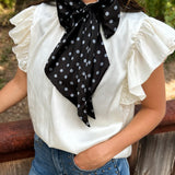 Black and white silky polka dot scarf with versatile styling options.