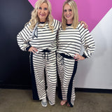 Black and white striped pant set with long sleeve top, wide-leg pants, and black trim.