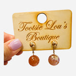 Water-resistant blush pink marbled drop earrings with gold posts and a 1.25-inch drop.