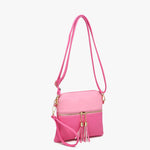 Pink crossbody bag with front zip pocket, adjustable strap, and gold hardware