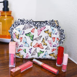 Quilted butterfly print bag with leopard ruffle trim and zipper closure.