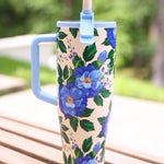 40 oz tumbler with blue floral print, handle, and flip straw lid.