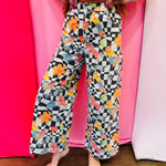 Black and white checkered wide-leg pants with colorful Western rodeo graphics.