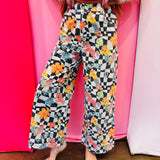 Black and white checkered wide-leg pants with colorful Western rodeo graphics.