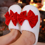 White closed-toe slippers with red bow accent, soft plush material, perfect for cozy lounging