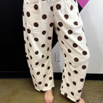 Cream barrel-leg pants with bold brown polka dots and elastic waistband.