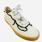 White low-top sneakers with vegan leather upper, delicate lace trim, lace-up closure, and round toe.