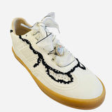 White low-top sneakers with vegan leather upper, delicate lace trim, lace-up closure, and round toe.