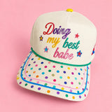Cream hat with rainbow polka dot bill and colorful Doing My Best Babe embroidery.