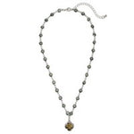 Gold-tone necklace with black diamond accents and black clover pendant, adjustable 16–18 inch length.