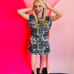Black and white geometric print mini dress with structured shoulders and an open back.