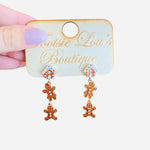 Gingerbread acrylic earrings with etched icing details, festive and lightweight for holiday wear.