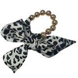 Oversized gold bead stretch bracelet with black and cream animal print scarf.