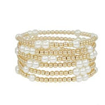 Gold beaded stretch bracelet with pearl accents, water resistant design.