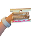 Six-piece water-resistant gold bead bracelet stack with round and rondelle beads.