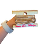 Six-piece water-resistant gold bead bracelet stack with round and rondelle beads.