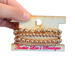 Water-resistant gold mixed bead stretch bracelet stack with four layered bracelets.