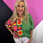 Green mixed print cotton top with retro florals, polka dots, collar, and puff sleeves.