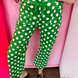 Green and white polka dot cropped barrel pants with drawstring waist and pockets.