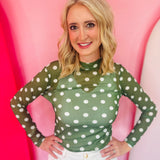 Green mesh top with white polka dots and mock neckline.