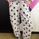 Grey barrel-leg pants with bold black polka dots and elastic waistband.