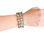 Water resistant grey beaded elastic bracelet with pearlescent beads and gold spacer accents.