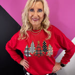 Red Christmas pullover with five patterned tree appliqués, shimmering sequins and gold star.