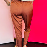 Cinnamon satin jogger-style pants with smocked elastic waistband, relaxed fit, and side pockets.