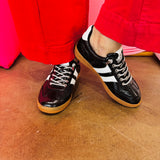 Black metallic Corky's sneakers with white side stripes and lace-up closure.