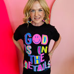 Black graphic tee with "God Is In The Details" in neon colors.