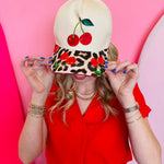 Tan hat with embroidered cherry and leopard cherry patterned bill.