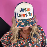 White and navy Jesus Loves You hat with colorful embroidery, floral bill, and cross detail.