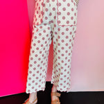 Pink high-waisted polka dot wide-leg pants with embroidered scalloped hem and side pockets.