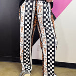 Orange leopard and black white checkerboard pants with bow details and vertical patchwork.