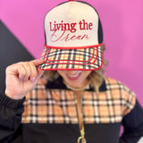 Cream and black Living The Dream hat with red embroidery and plaid printed bill.