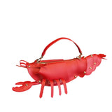 Red quilted lobster purse with rivet accents and beach-inspired design.