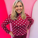 Maroon mesh top with white polka dots and mock neckline.