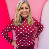 Maroon mesh top with white polka dots and mock neckline.