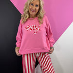 Pink Christmas sweatshirt with red and white candy cane-inspired corded MERRY lettering.