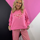 Pink Christmas sweatshirt with red and white candy cane-inspired corded MERRY lettering.