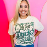 Natural tone St. Patrick’s Day tee with “Oh For Luck’s Sake” graphic, clovers, and rhinestone accents.